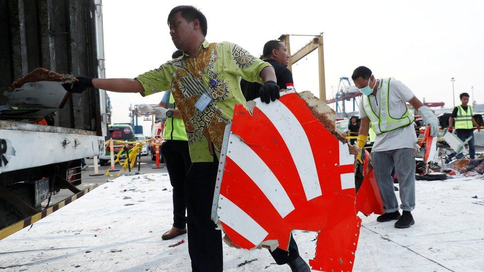 Workers load up recovered debris and belongings believed to be from Lion Air flight JT610 onto a truck at Tanjung Priok port in Jakarta