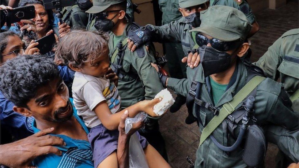 People offer rice pudding to army soldiers to celebrate the resignation of Gotabaya Rajapaksa as president of Sri Lanka, outside the Presidential Secretariat in Colombo, Sri Lanka, 15 July 2022