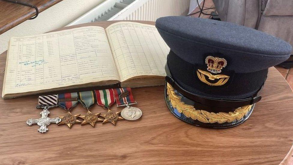 row of medals, captain's hat and logbook