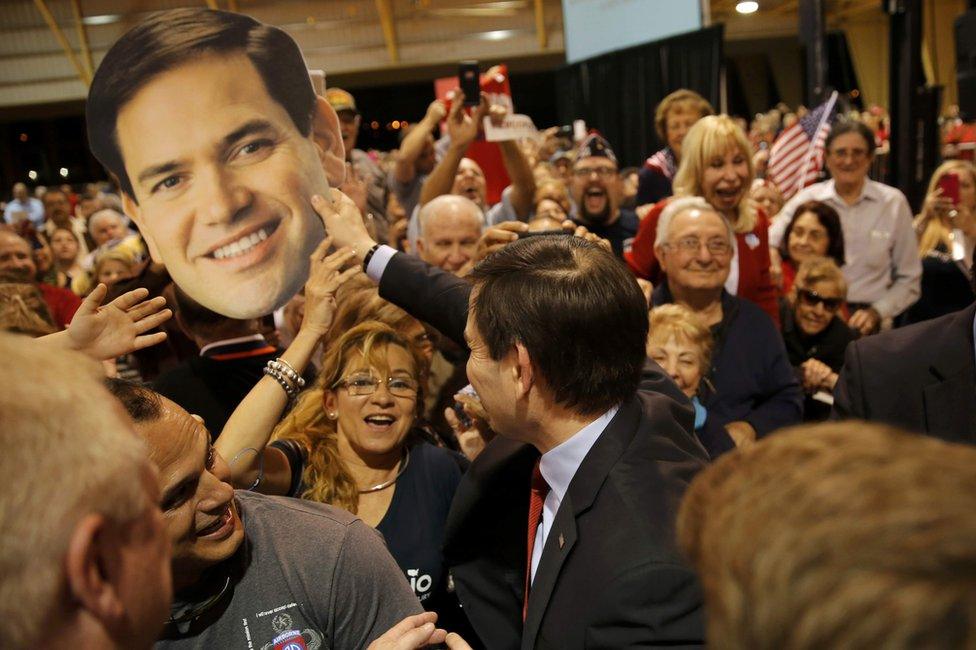 Marco Rubio plays with a cut-out of his own face at a rally in Miami, Florida