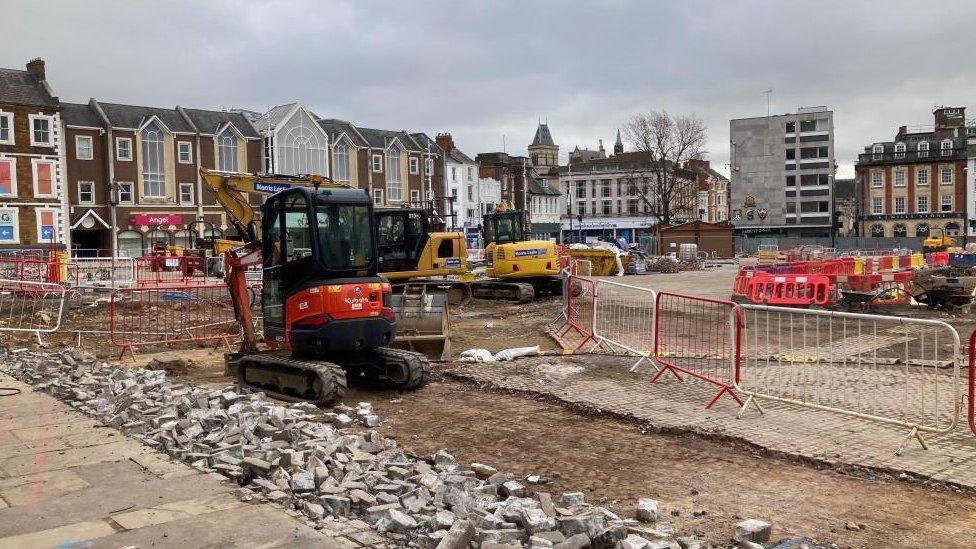 Market Square, showing broken paving stones, diggers and barriers