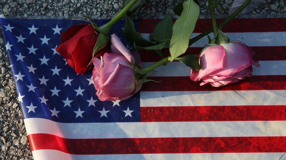 Flowers and an American flag are seen on the ground near the Pulse Nightclub where Omar Mateen allegedly killed at least 50 people on June 13, 2016 in Orlando, Florida