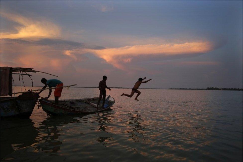 A person jumps in the flooded river Ganges in Allahabad, India, Thursday, Aug. 25, 2016