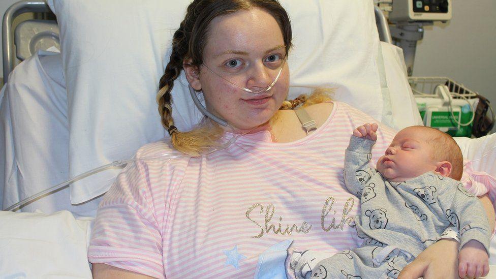 Ellie Wright in a hospital bed with baby Leo.