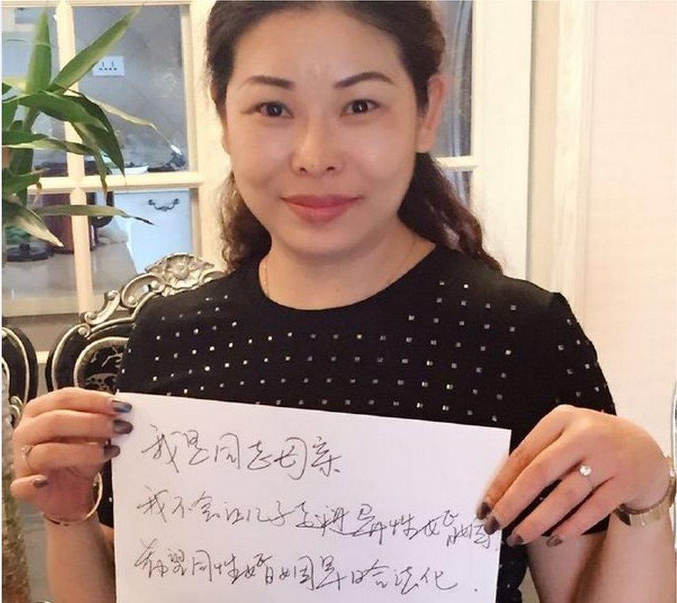 Picture of Chinese parent holding up a sign declaring they would not pressure their children into marriage.