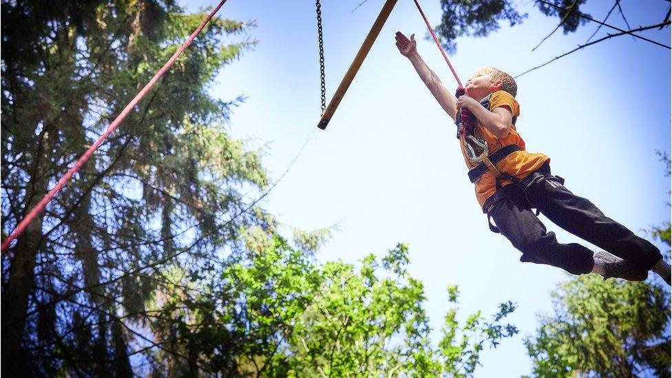 Boy in harness grabs swing