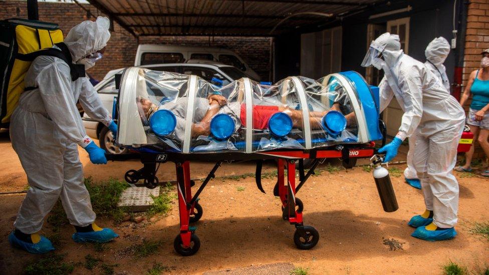 Members of the Tshwane Special Infectious Unit on COVID-19 wearing personal protective equipment (PPE) pick up a suspected COVID-19 patient on January 15, 2021 in Pretoria, South Africa.