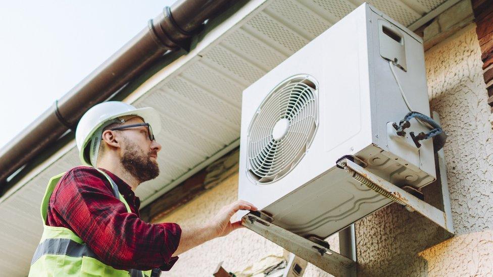 Man repairing heat pump