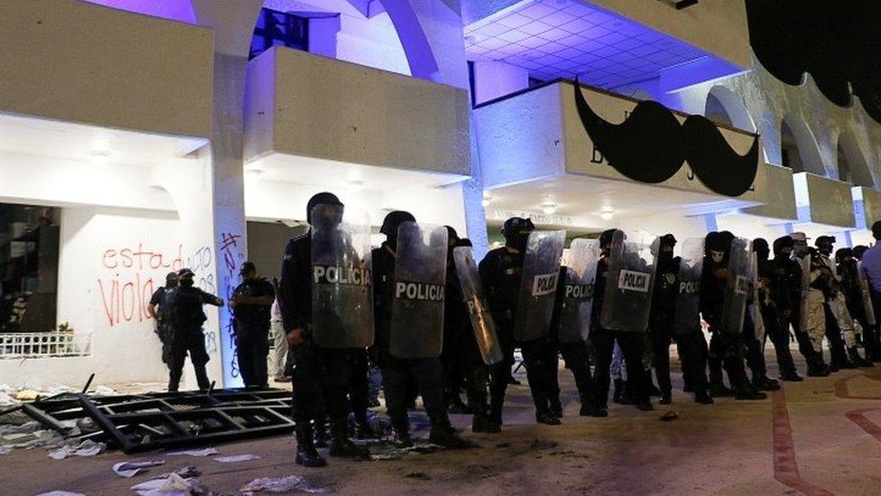 Riot police officers keep watch outside the Municipal Palace after a protest to demand justice for the murder of Blanca Alejandrina, known as Alexis, which was disbanded by the police with shots into the air to disperse demonstrators who were vandalizing the government premises, in Cancun, Mexico November 9, 2020.