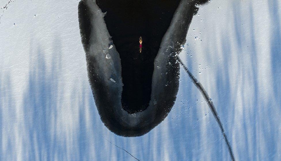 Aerial view of a swimmer in a pool carved out of a frozen lake at Beiling Park on 3 December in Shenyang, China