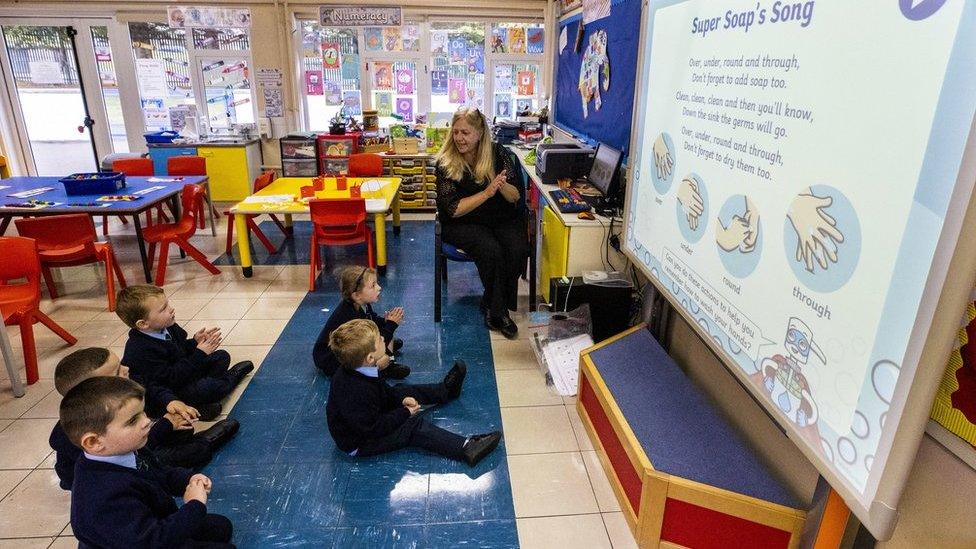 A teacher with five pupils in a school classroom