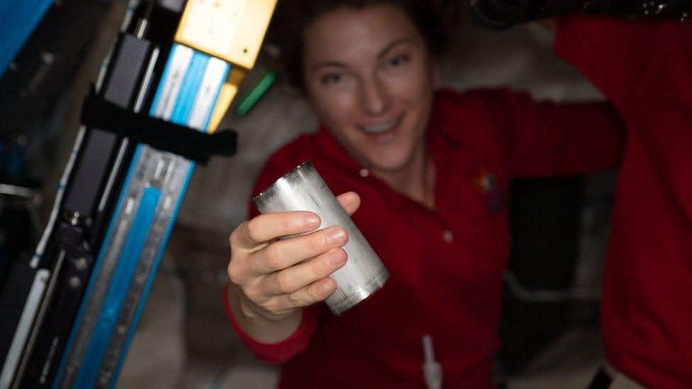 NASA astronaut Kayla Barron replaces a filter in the space station's smart water processing equipment.