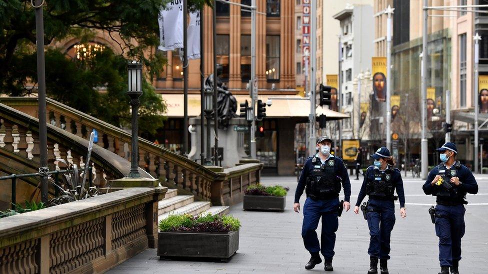 Police walking through deserted central Sydney during lockdown