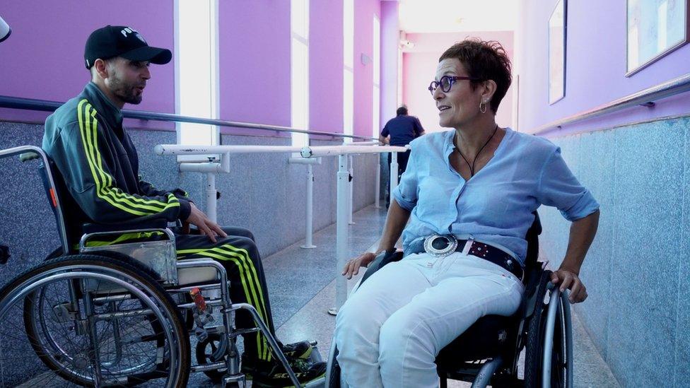 Amina Slaoui speaks to a patient in the corridor of the clinic.