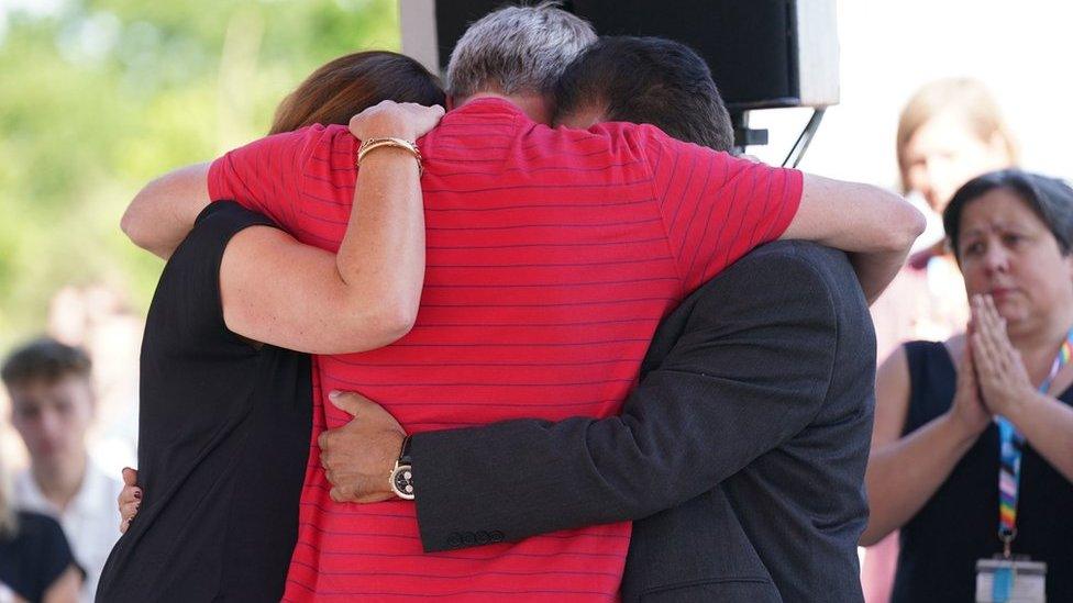 Grace O'Malley Kumar's father (right) and Barnaby Webber's parents embrace during a vigil at the University of Nottingham