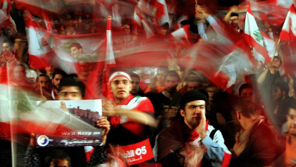 Lebanese opposition supporters wave flags after Bashar al-Assad said Syria would redeploy its troops in Lebanon (5 March 2005)