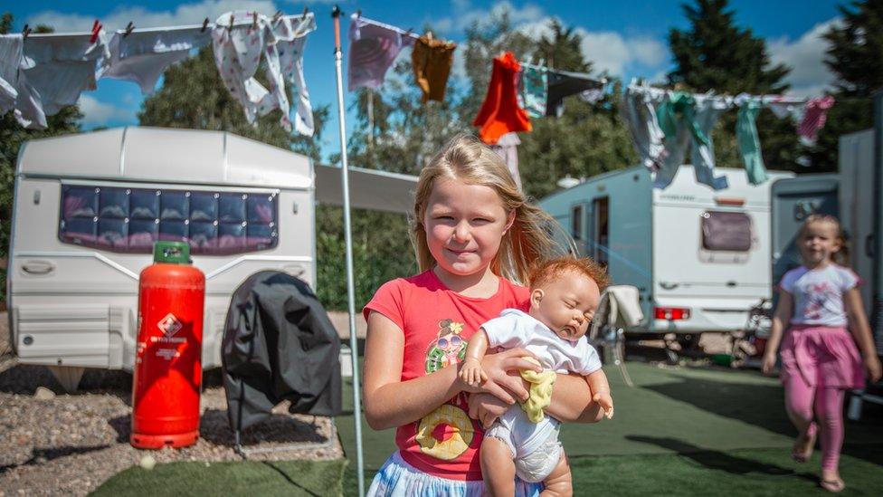 One of the children holding a baby doll