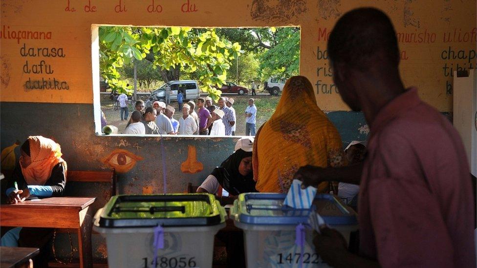 Tanzanians cast their ballots for the Tanzanian presidential elections as others queue at a polling station on October 25, 2015 in Zanzibar