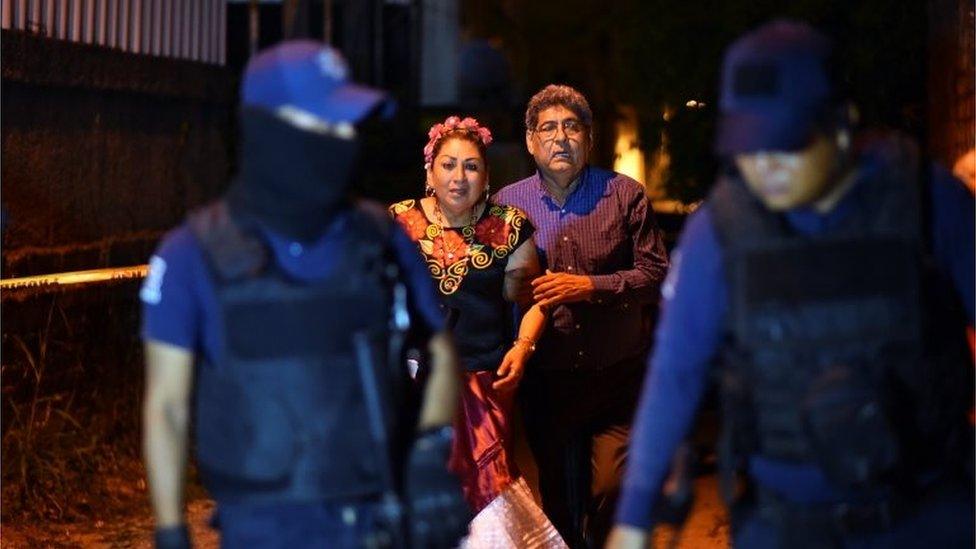 People react next to police officers guarding a crime scene where unidentified assailants opened fire at a bar in Minatitlan, in Veracruz state, Mexico, April 19, 2019.