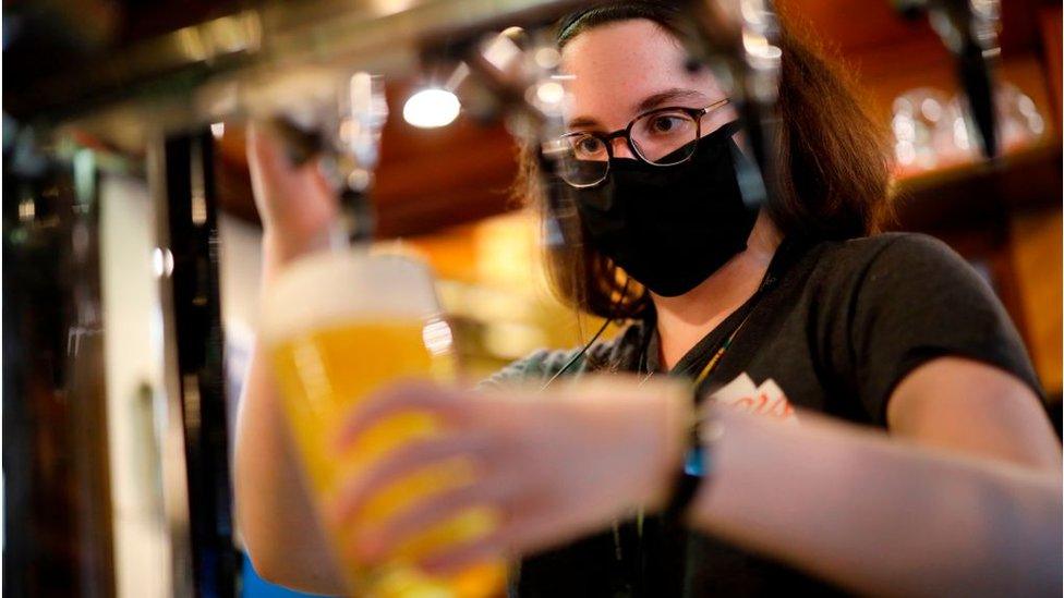 Bar staff member pours pint