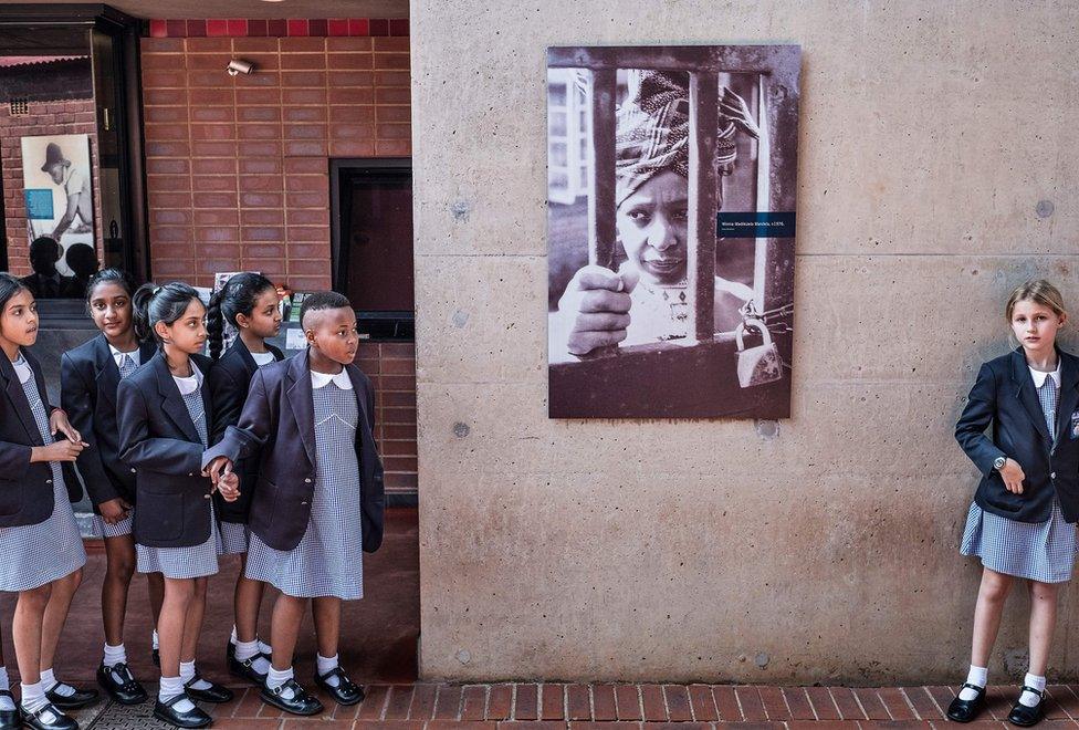 South African school children pause next to a portrait of the late South African anti-apartheid campaigner Winnie Madikizela-Mandela at her house in Soweto - 3 April 2018