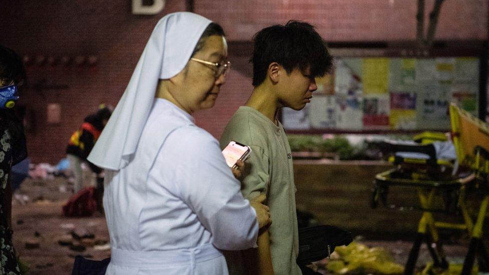 A nun leading a protester out of PolyU