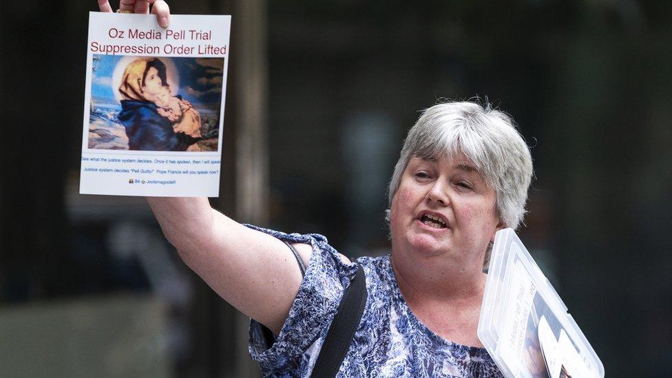 A woman protests outside George Pell's court hearing on Tuesday holding up a sign which reads "Oz Media Pell Trial Suppression Order Lifted"