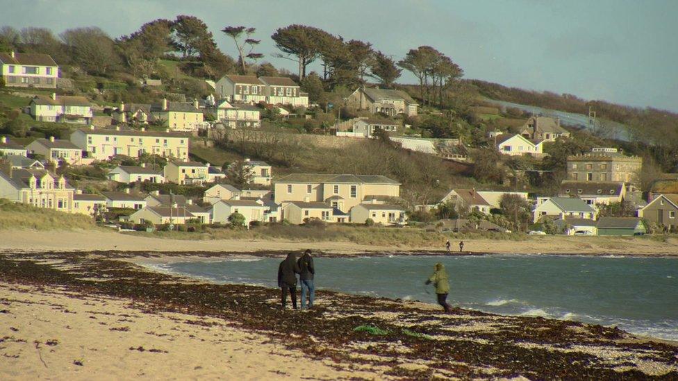 People walk on a Cornish beach