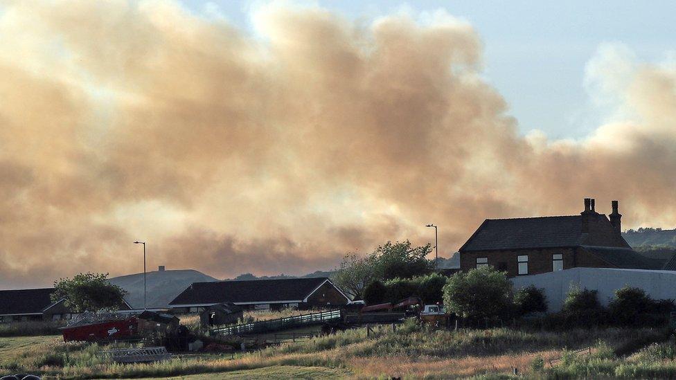 houses against backdrop of fire