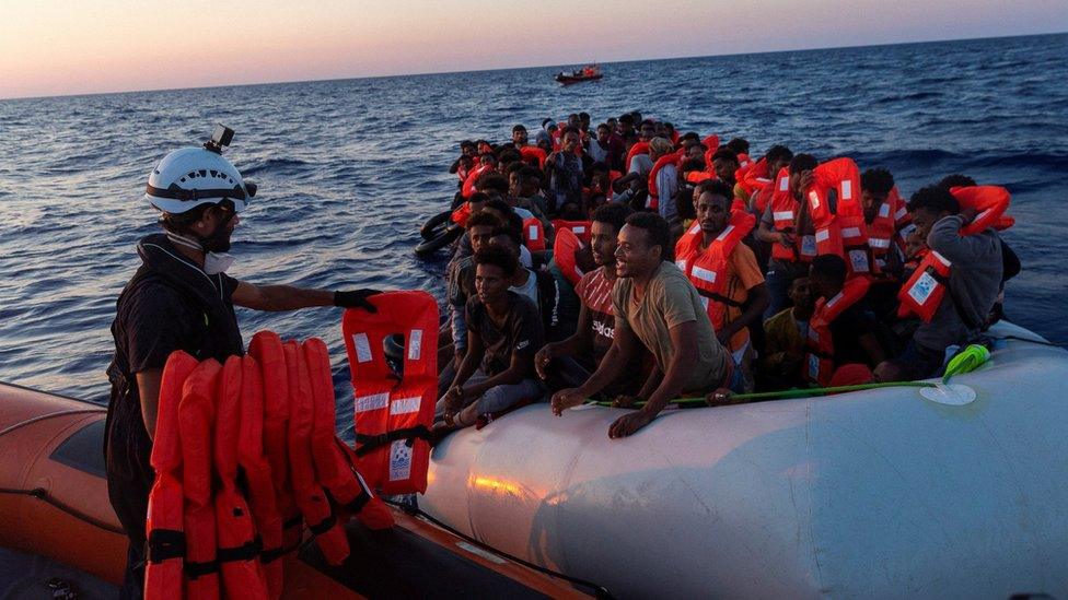 Migrants being handed life jackets