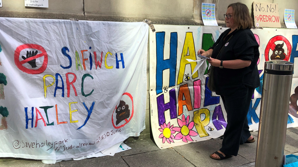 Protest banners and woman handing out leaflets