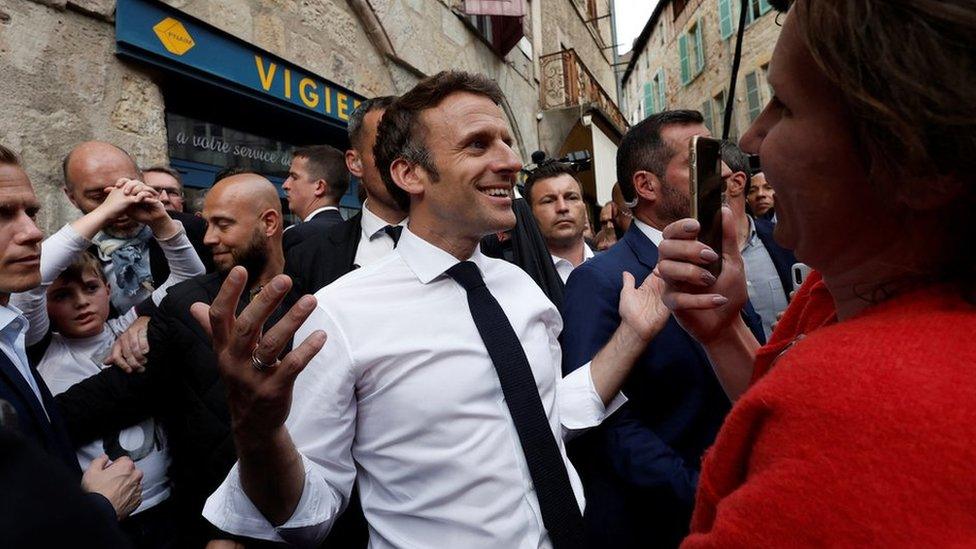 French President Emmanuel Macron, candidate for his re-election in the 2022 French presidential election, reacts as he meets with supporters after a campaign rally in Figeac