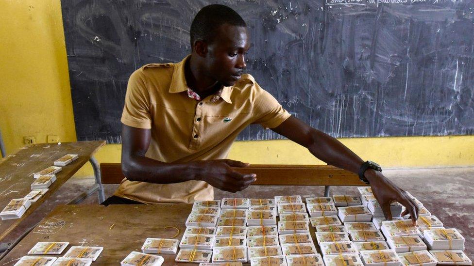 An election official checks voter ID cards in Dakar