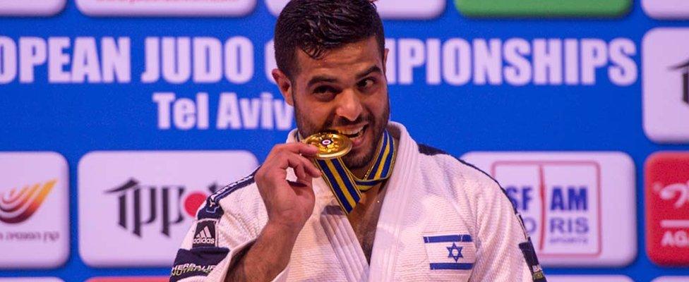 Under 81kg gold medallist, Sagi Muki of Israel symbolically tastes the medal