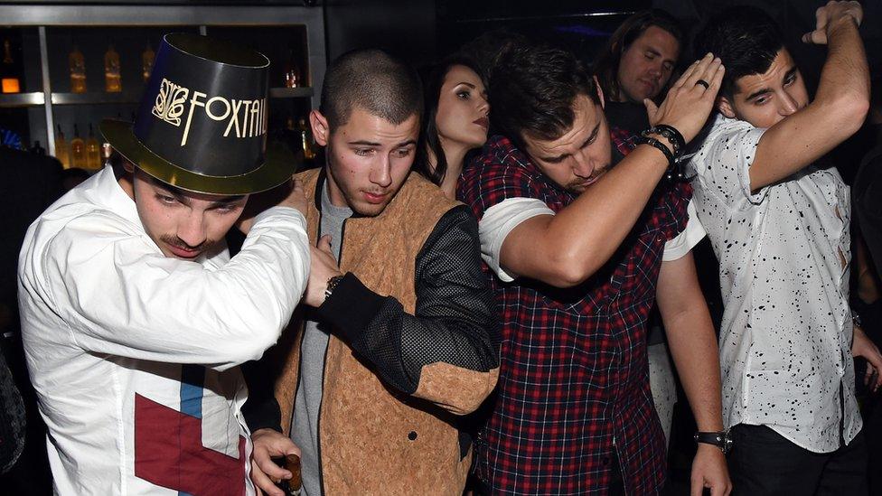 Pop band The Jonas Brothers do the dab at a new year's eve show in Las Vegas