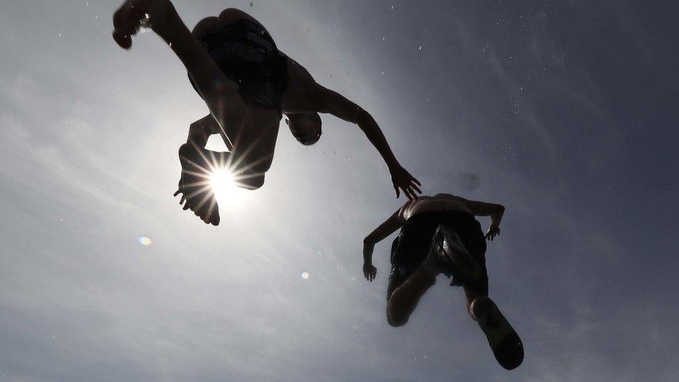 Boys jumping into water