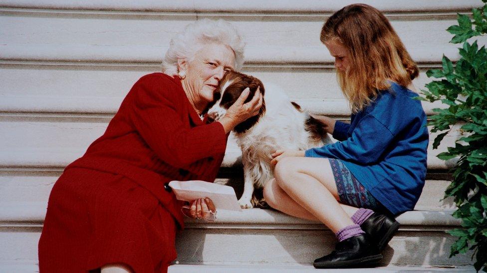 Barbara Bush pets her dog Millie while waiting with her grandaughter Barbara for President George H.W. Bush to arrive on White House steps in this undated photo in Washington, DC.