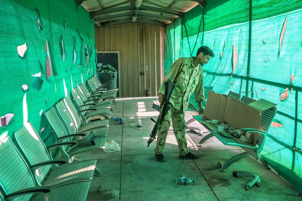 An Afghan army soldier surveys belongings left by the US military inside the Bagram Air Base, some 50 kilometers north of the capital Kabul.