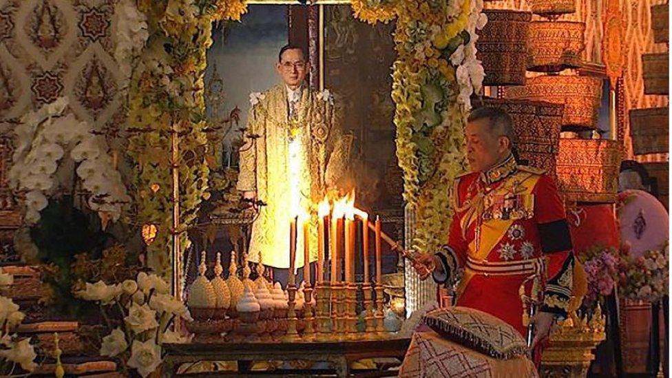 King Maha Vajiralongkorn lighting a candle during the ceremony