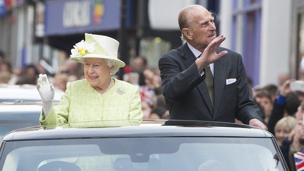 The Queen and Prince Philip waving at wellwishers