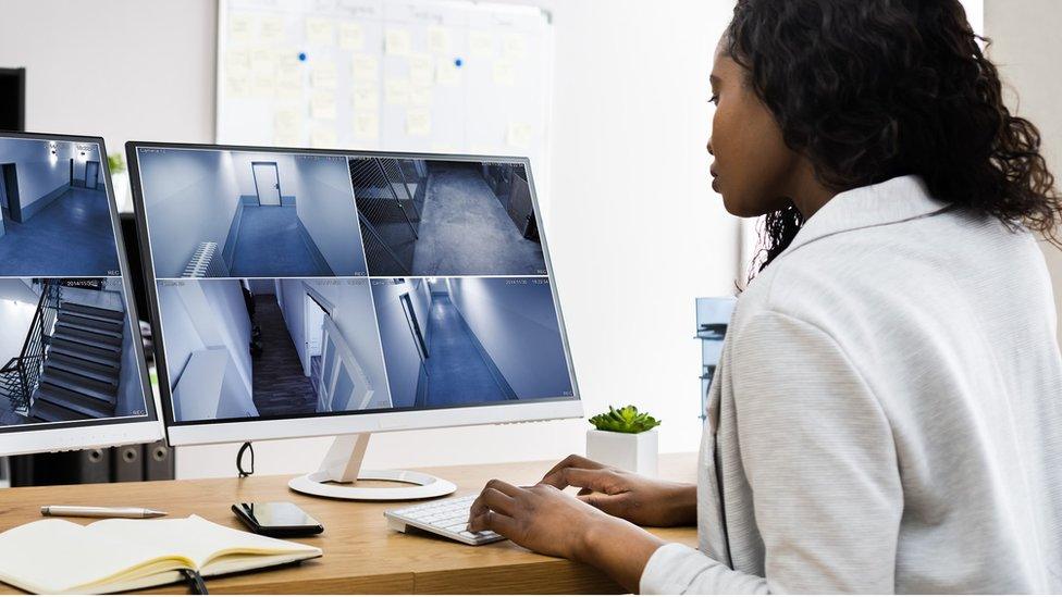 A woman looking at CCTV images