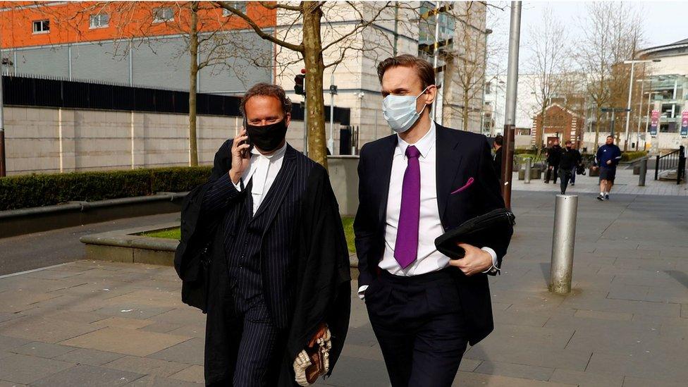 Dr Christian Jessen walks with a lawyer outside the court in Belfast