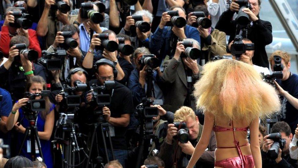 A Model On The Catwalk At The Topshop Unique Fashion Show in front of rows of photographers