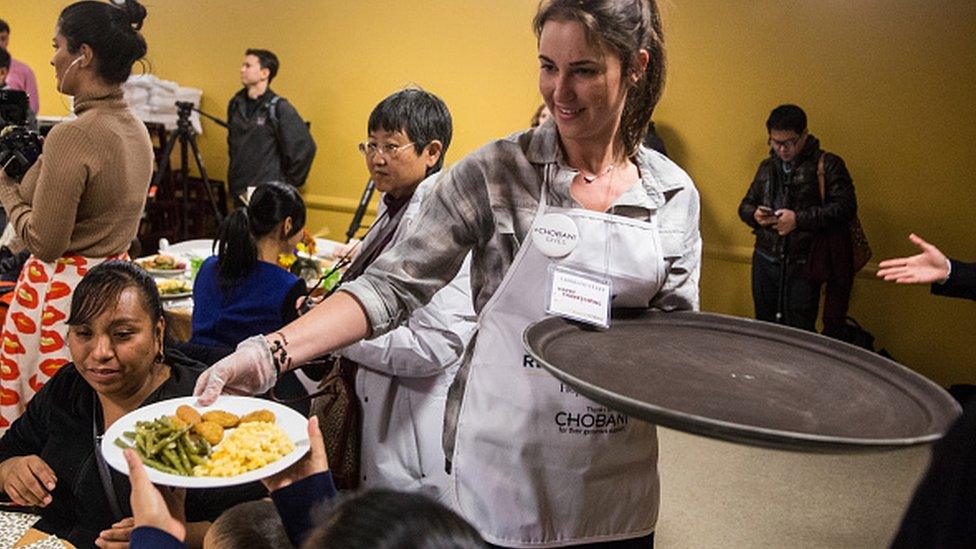 A volunteer serving Thanksgiving meals to people who need it the most.