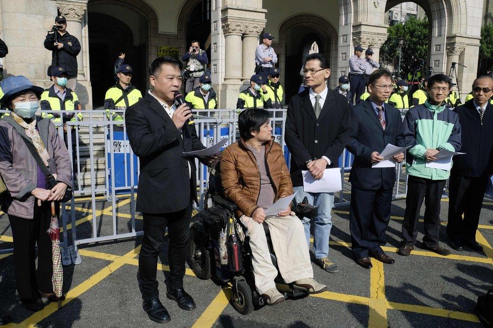 Anti same-sex marriage activists speak to the press outside the Judicial Yuan in Taipei on 24 March 2017.