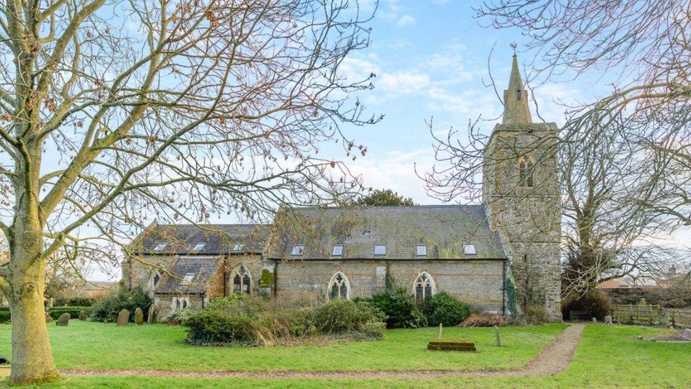 Medieval church standing in large grounds with a narrow path