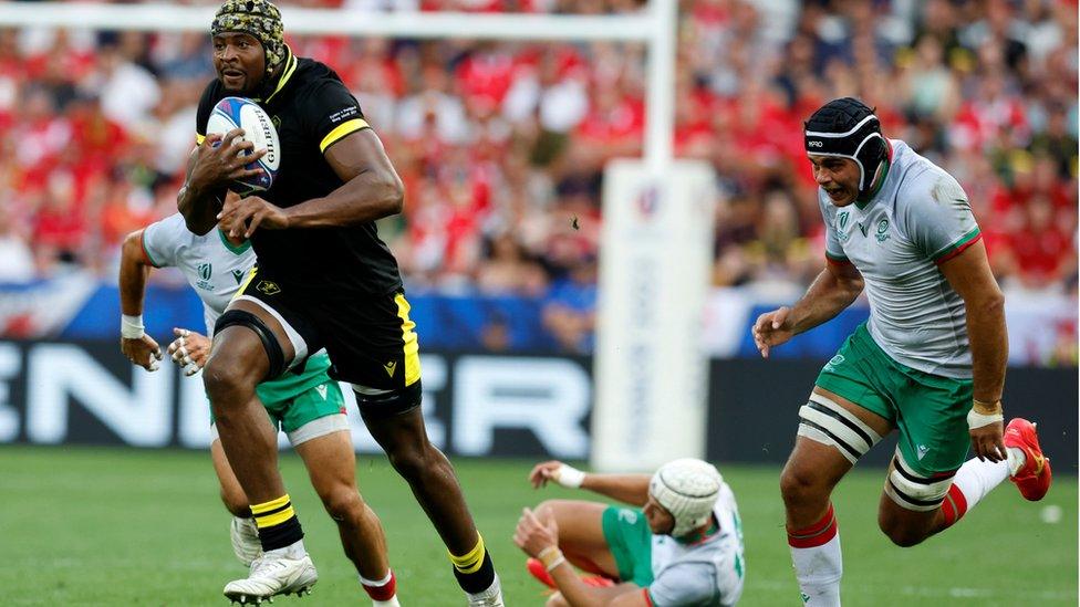 Christ Tshiunza running with the ball at the Wales v Portugal game