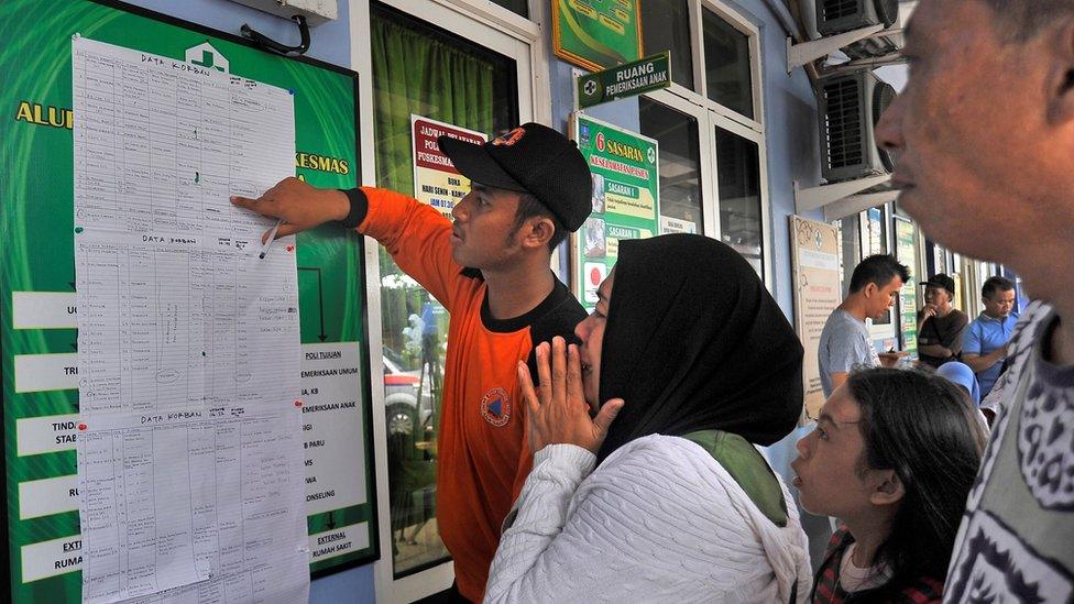 A women cries as she reads a list of victims who were killed in a tsunami, at Carita in Padeglang, Banten province, Indonesia, December 23, 2018