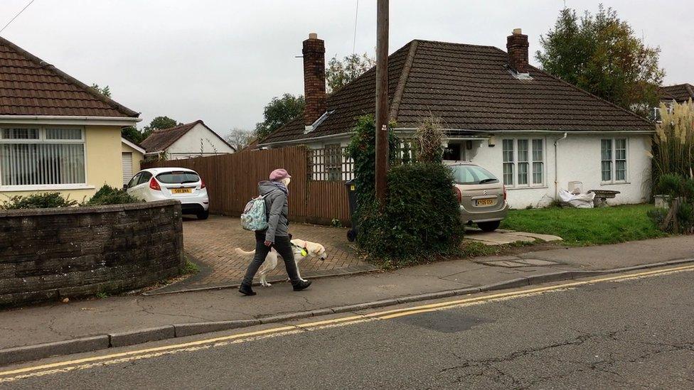 Sian Healey walking down the street with her guide dog Uri