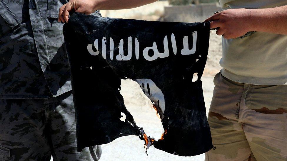 Syrian soldier sets fire to an Islamic State (IS) group flag on April 4, 2016